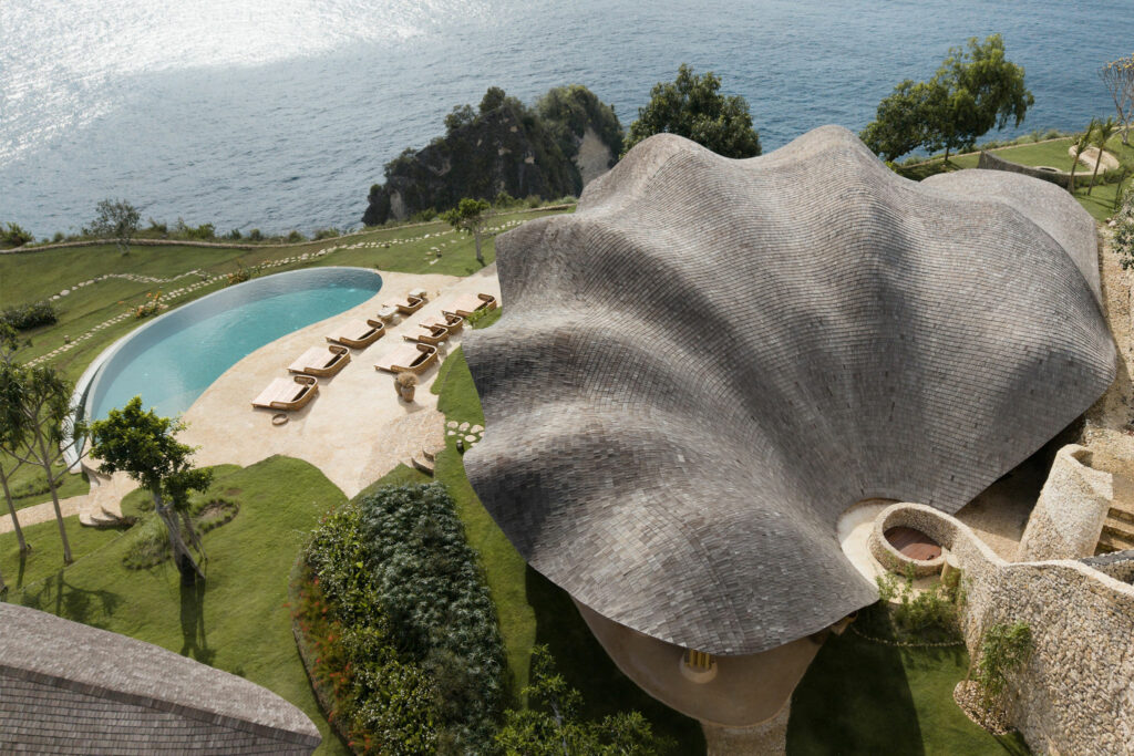 Aerial view of a shell-shaped restaurant building at a luxury retreat in Bali.