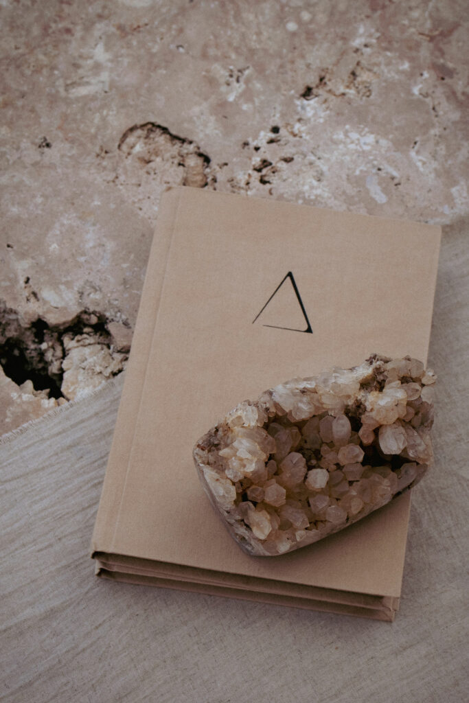 Open journal with dried flowers on a stone surface at a Bali retreat.