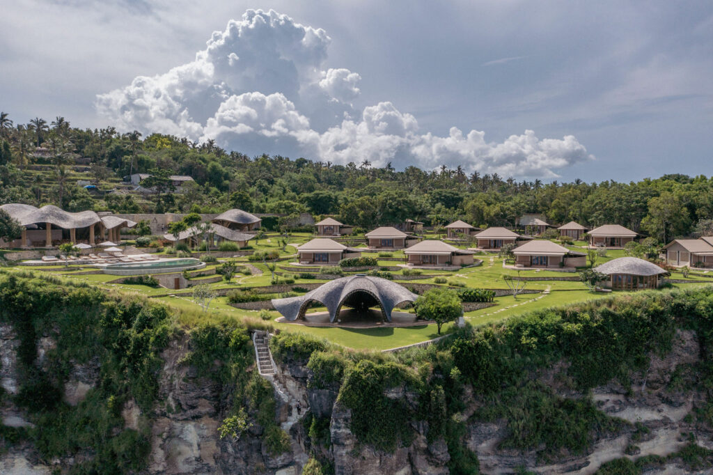 Aerial view of a cliffside luxury retreat surrounded by ocean in Bali.